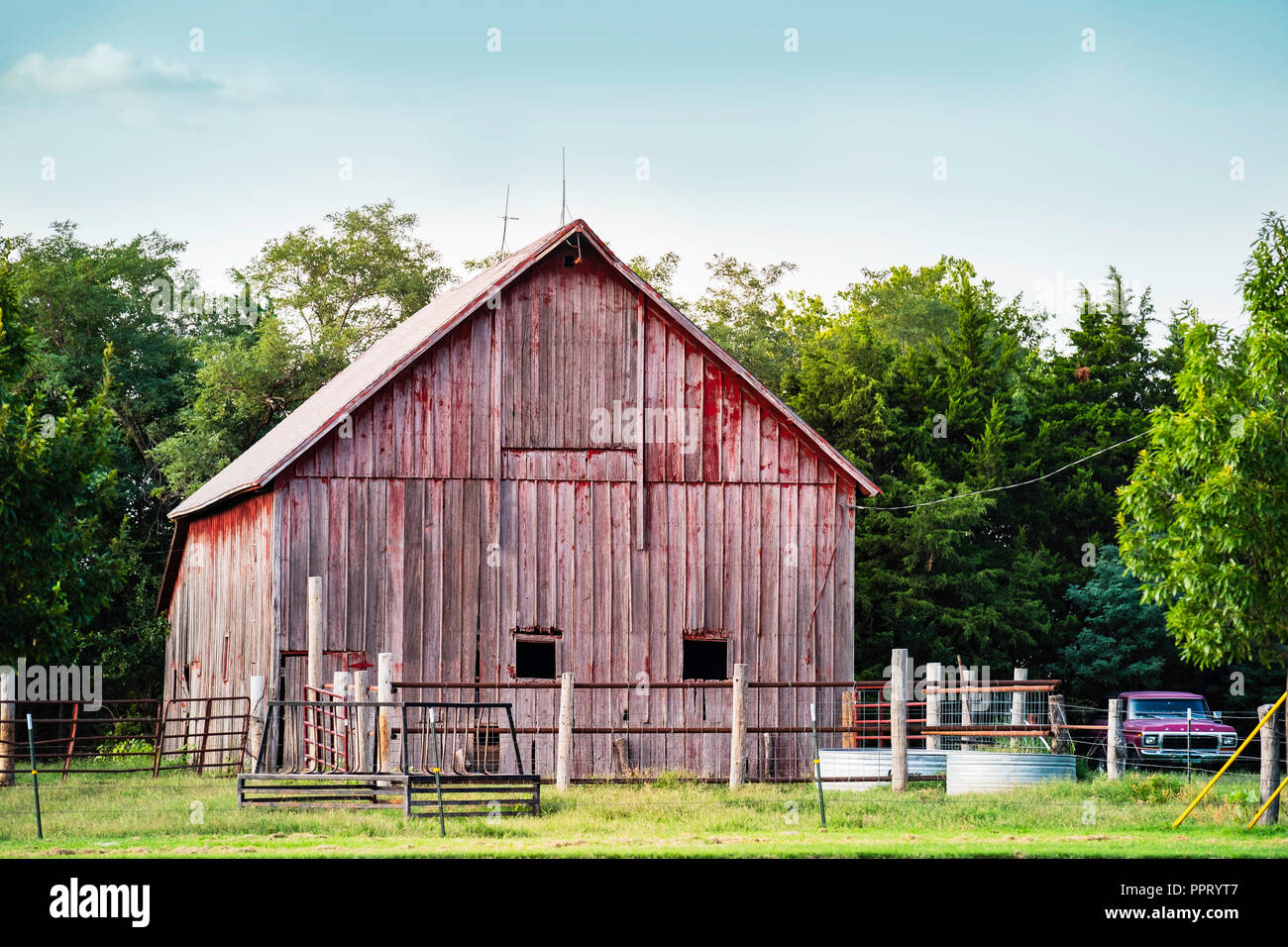 Old faded red wooden barn  beside a road in the countryside outside of Wichita, Kansas, USA. Stock Photo