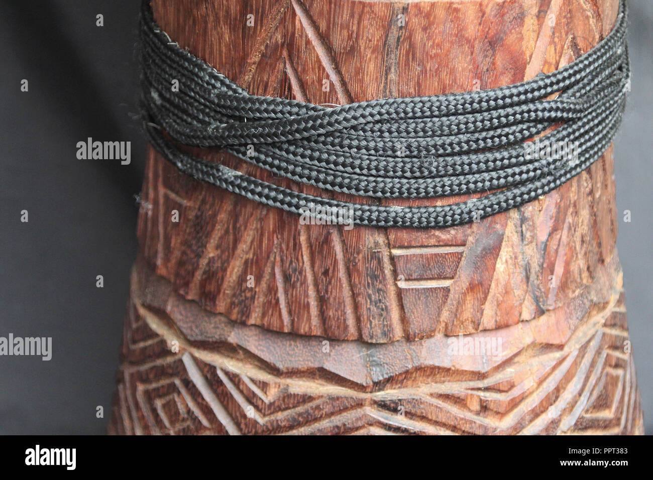 far view of a wooden African djembe design with tuning ropes on the