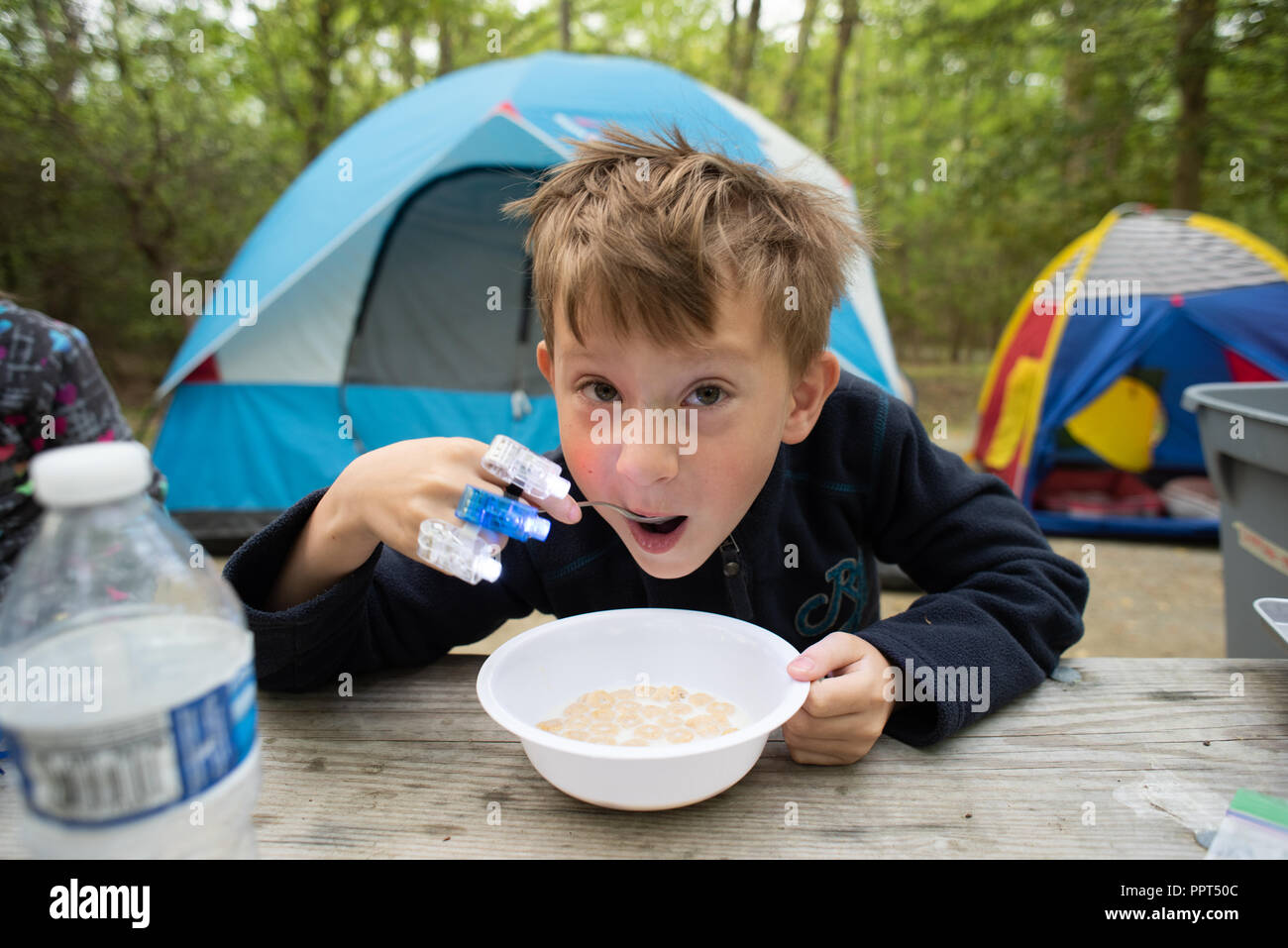 A Boy Eats Cereal While Camping At Elk Neck State Park Stock Photo
