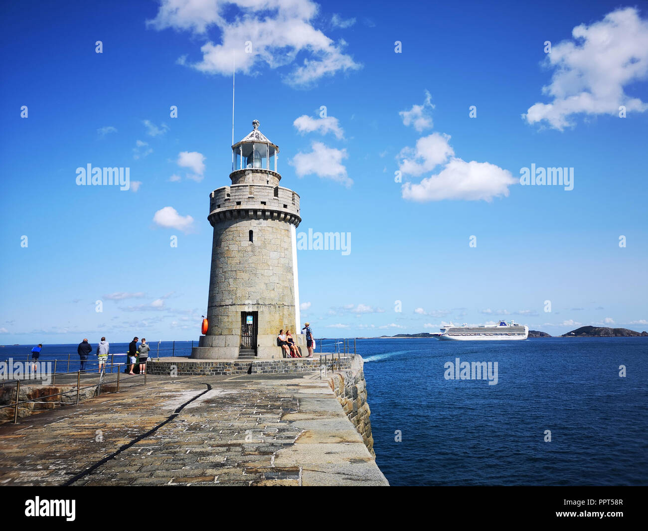 Guernsey, UK: August 25, 2018: The St Peter Port harbour breakwater and lighthouse in Guernsey. Stock Photo