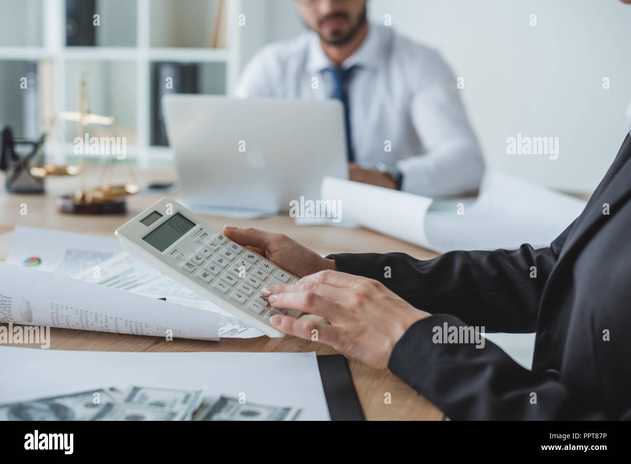 cropped image of financiers using calculator and laptop in office Stock Photo