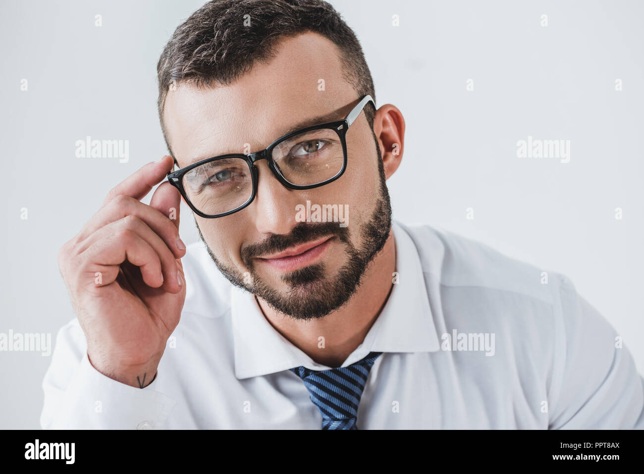 portrait of smiling handsome businessman in glasses looking at camera ...