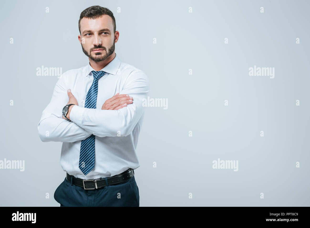 handsome businessman standing with crossed arms isolated on grey Stock ...