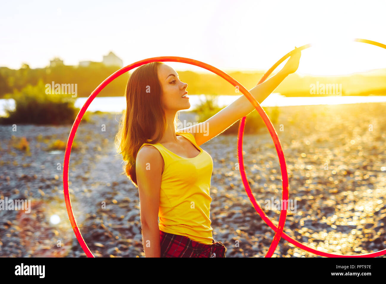 woman rotates hula hoop on nature background Stock Photo - Alamy