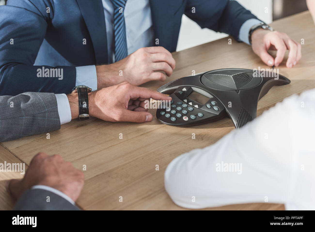 cropped shot of business people using conference phone Stock Photo