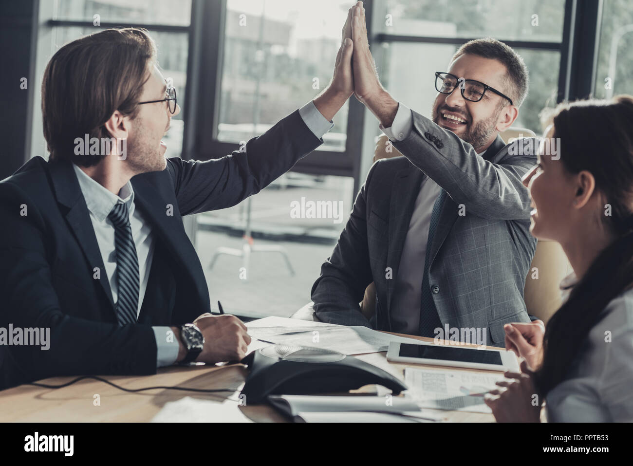 happy business people giving high five during meeting at modern office ...