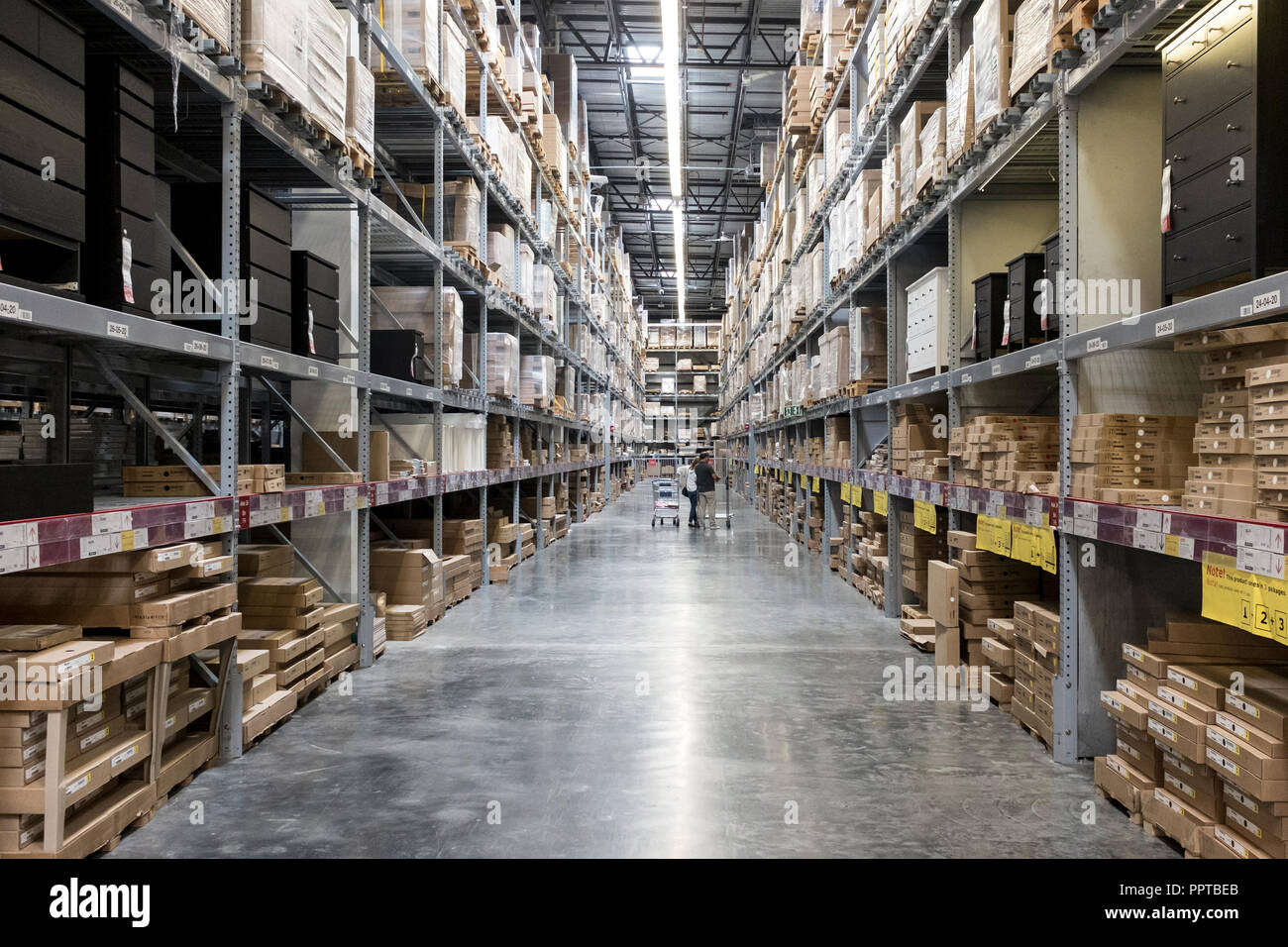 Shoppers looking for flat packed furniture stored on racks in a warehouse in Miami, USA Stock Photo