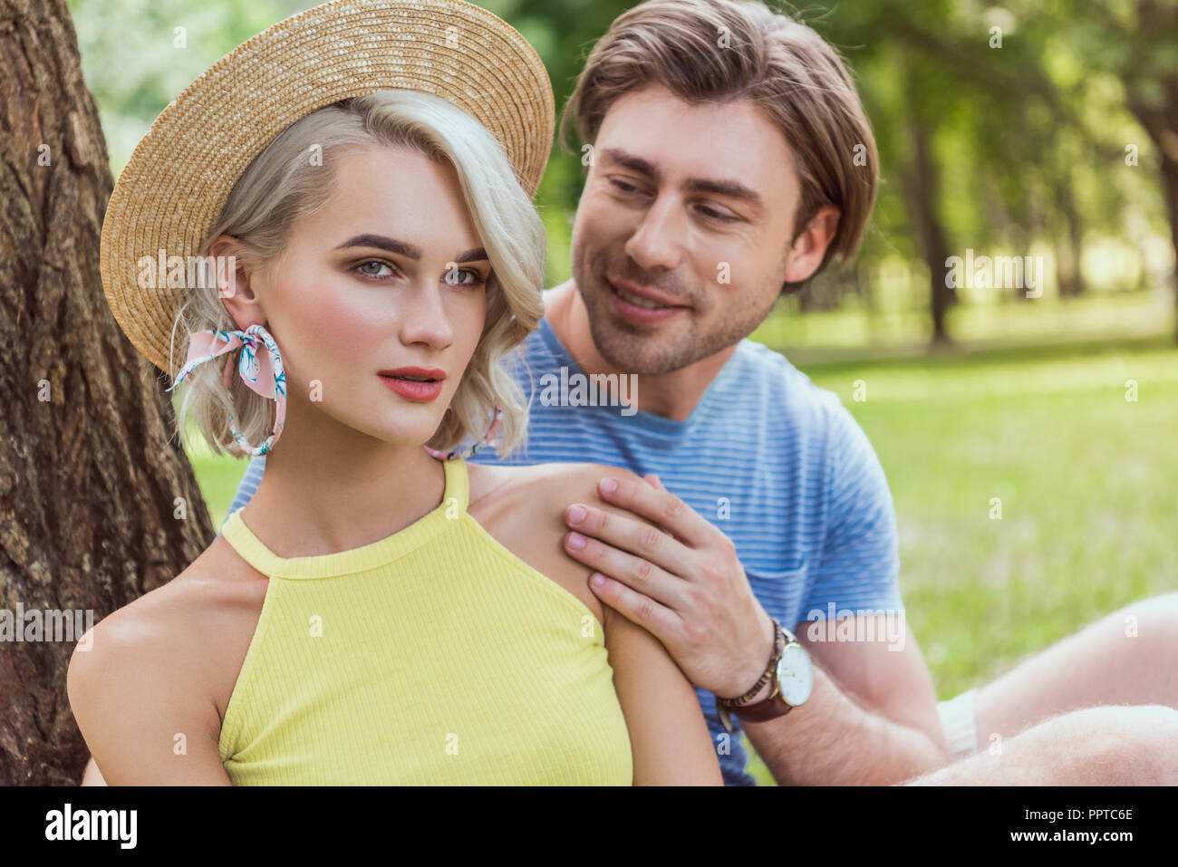 boyfriend hugging girlfriend in straw hat in park Stock Photo - Alamy