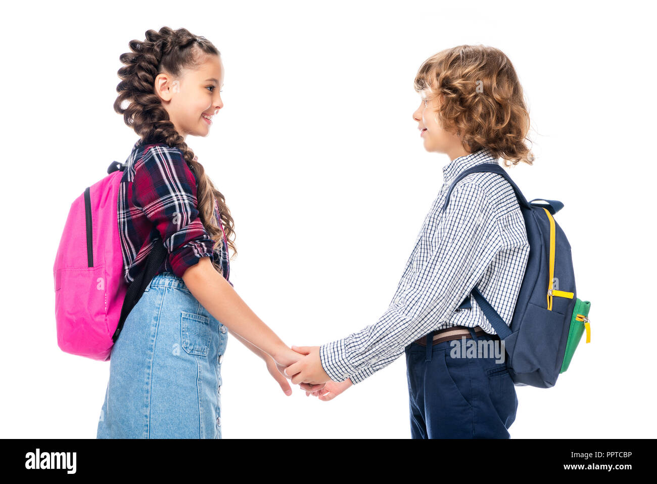 side view of classmates holding hands and looking at each other isolated on white Stock Photo