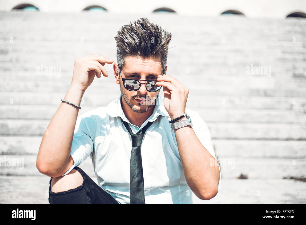 Depressed unsuccessful businessman feels terrible headache, hands shocked by bankruptcy stock downfall sitting on stone stairs. Stressed tired man fee Stock Photo