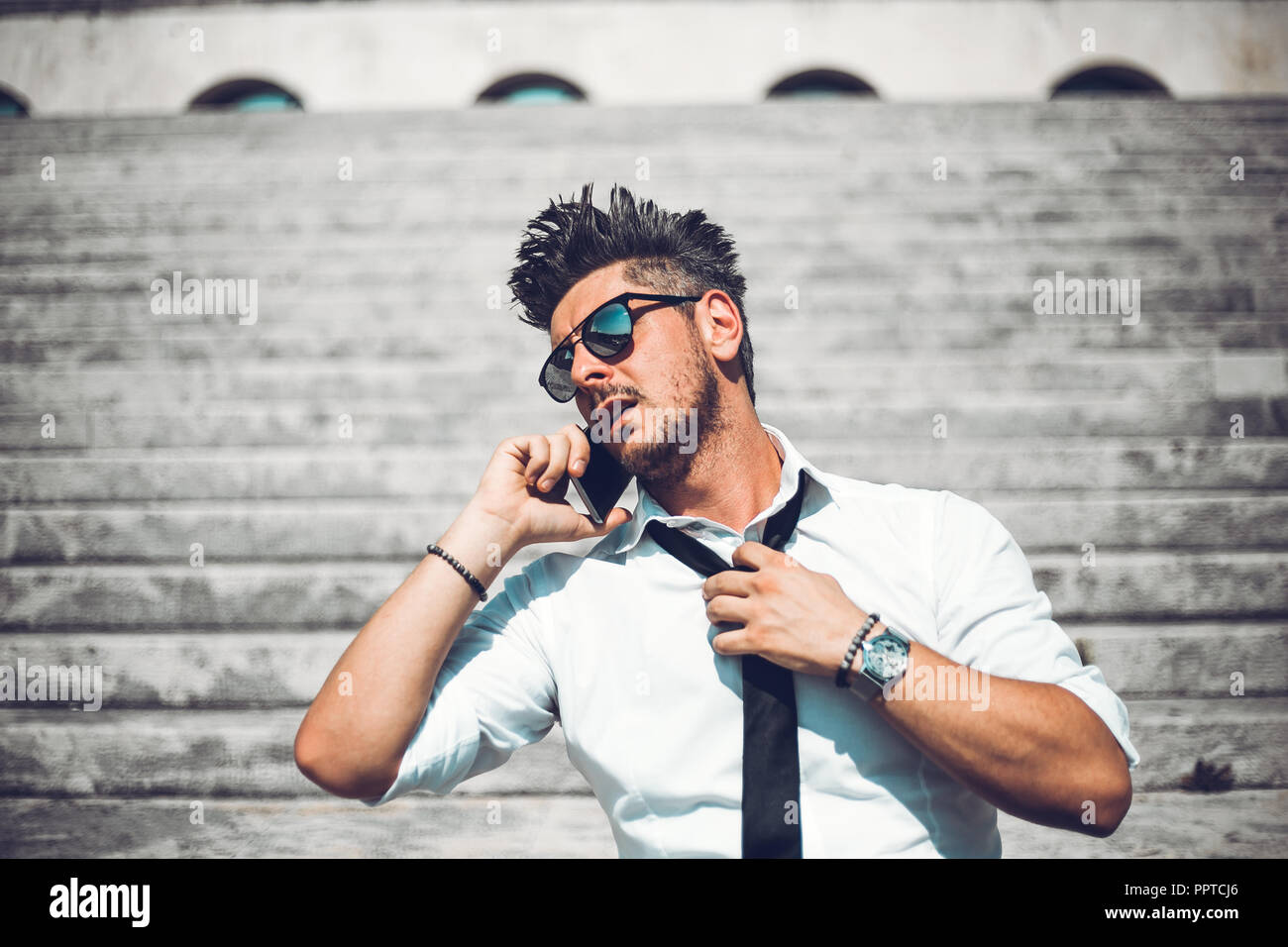 Depressed unsuccessful businessman feels terrible headache, hands shocked by bankruptcy stock downfall sitting on stone stairs. Stressed tired man fee Stock Photo