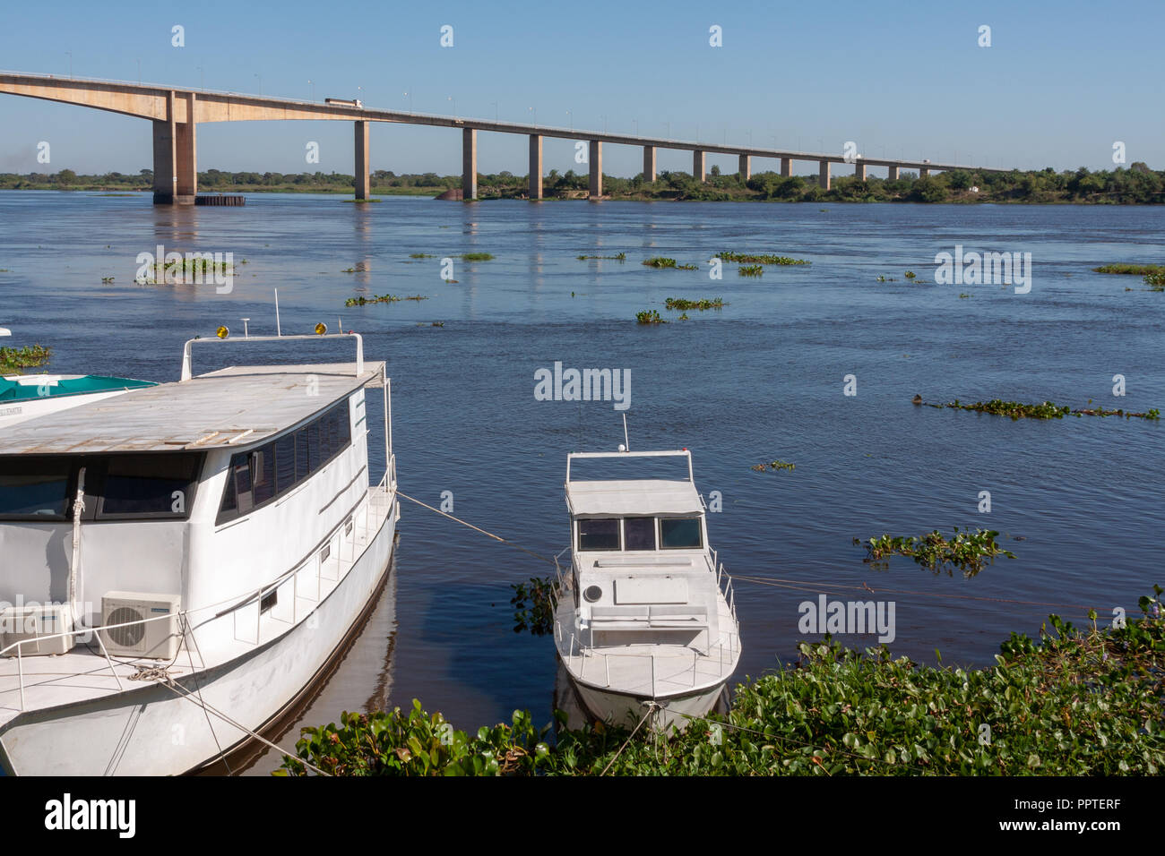 Boats at riverside, Rio (River) Paraguay, Puente (Bridge) Remanso Castillo on the background, Mariano Roque Alonso, Paraguay Stock Photo