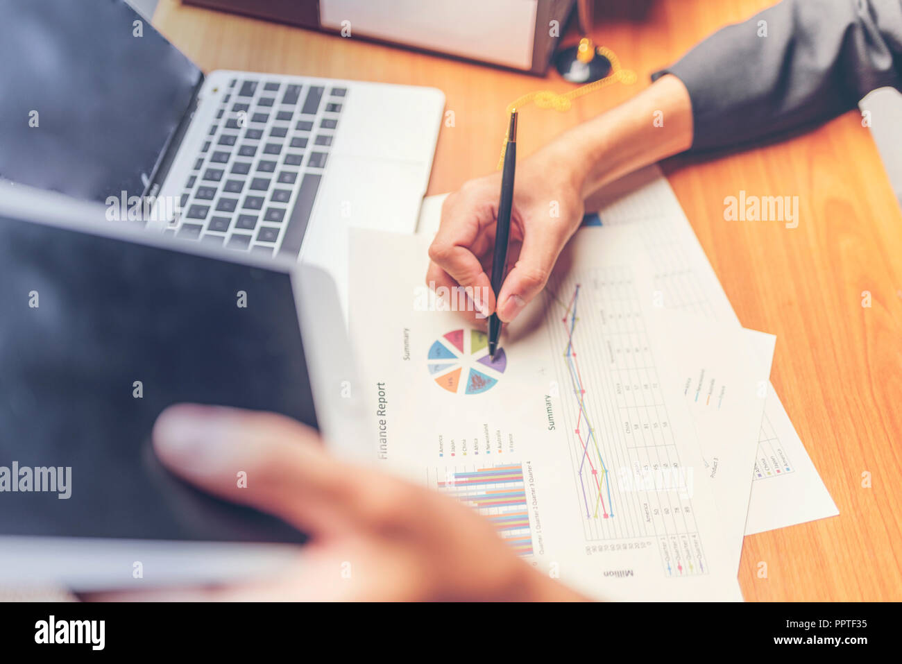 Businessmen are analyzed data from report using smartphone and laptop computer. Stock Photo