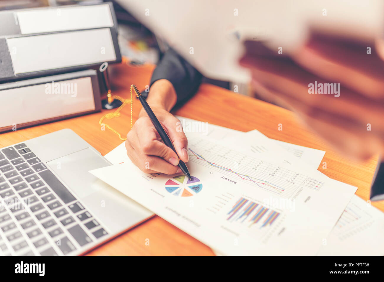 Businessmen are analyzed data from report using smartphone and laptop computer. Stock Photo