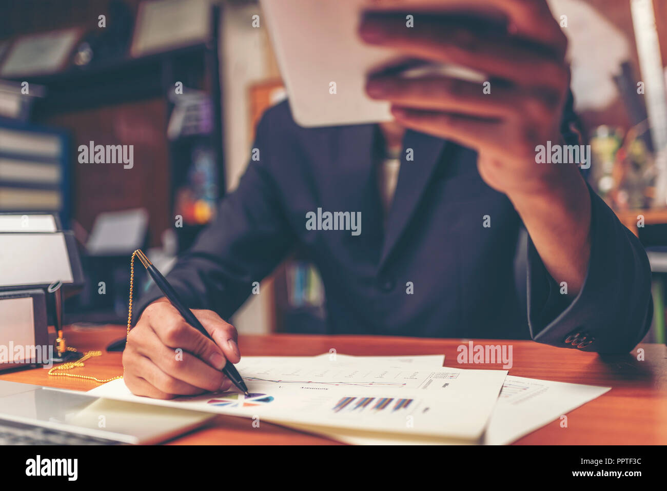 Businessmen are analyzed data from report using smartphone and laptop computer. Stock Photo