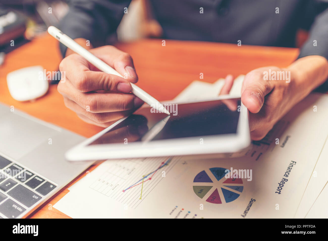 Businessmen are analyzed data from report using smartphone and laptop computer. Stock Photo