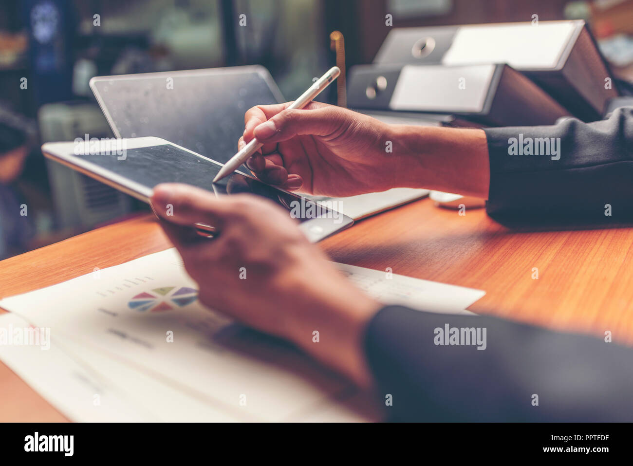Businessmen are analyzed data from report using smartphone and laptop computer. Stock Photo