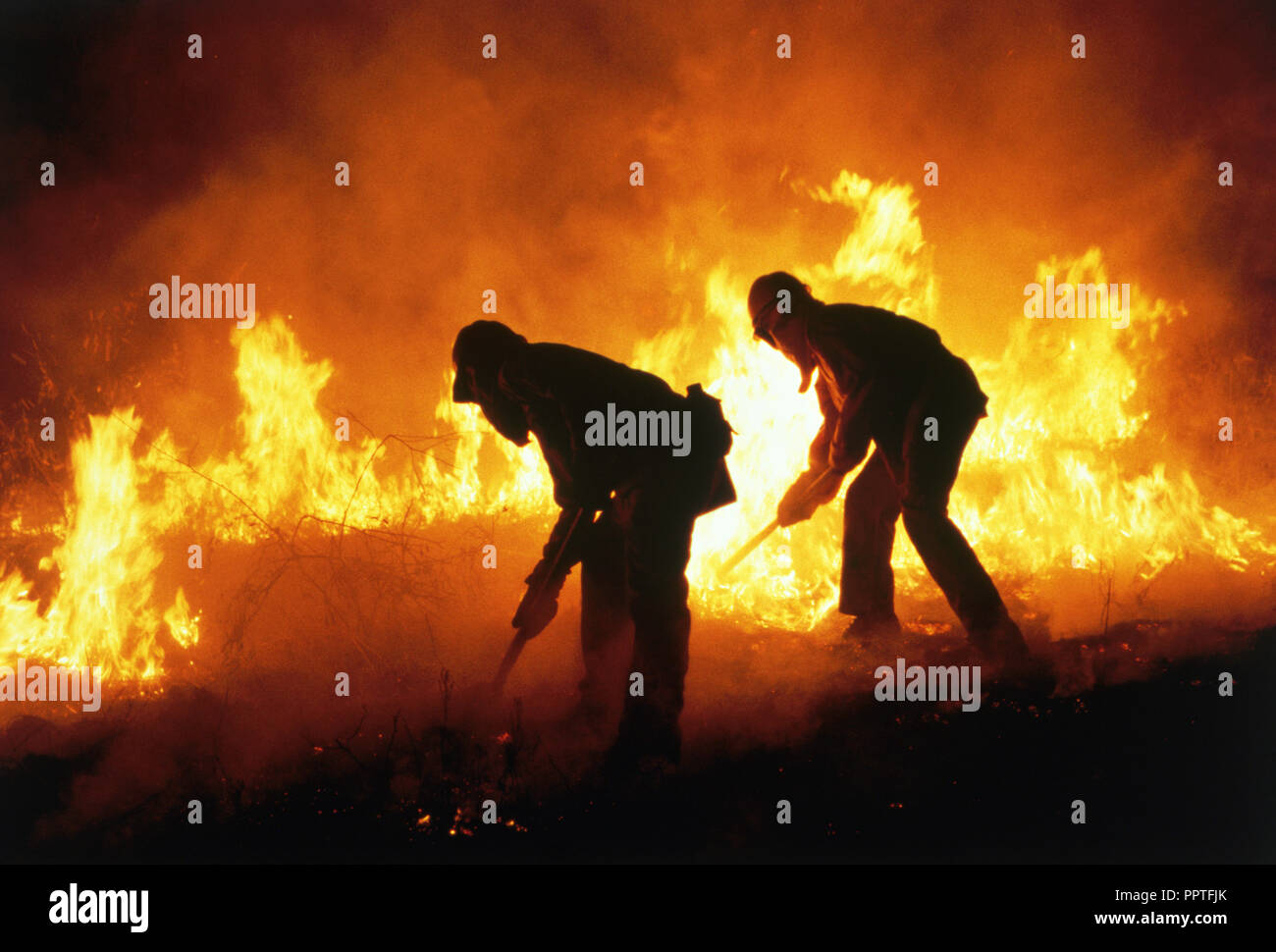 Silhouettes of firemen fighting a brush fire in California, USA Stock Photo