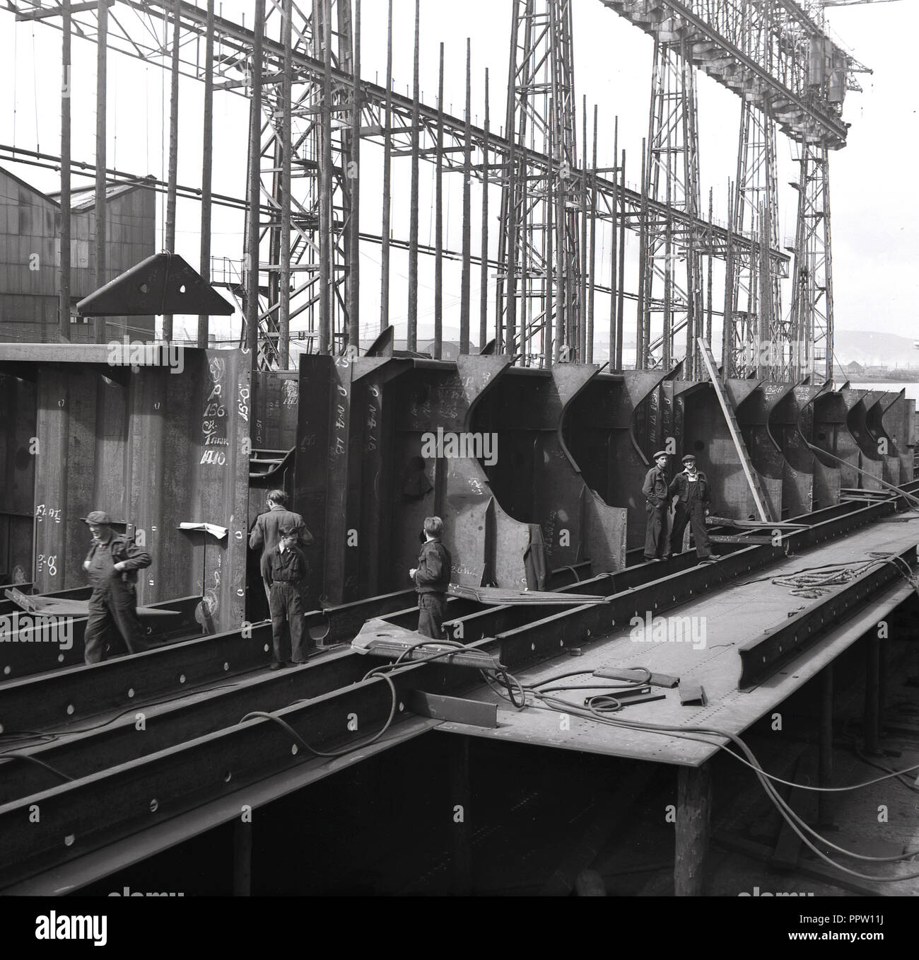 1950s, historical, workers at the shipyard of Harland and Wolff shipbuilders in Belfast, Northern Ireland, UK. The yard on Queen's Island, River Lagan with its giant gantries, was busy during WW2 and in the years following and remained a major shipbuilding centre until the early 1960s, when overseas competition from the far east and the rise of jet-powered aircraft saw the yard's orders decline. Stock Photo