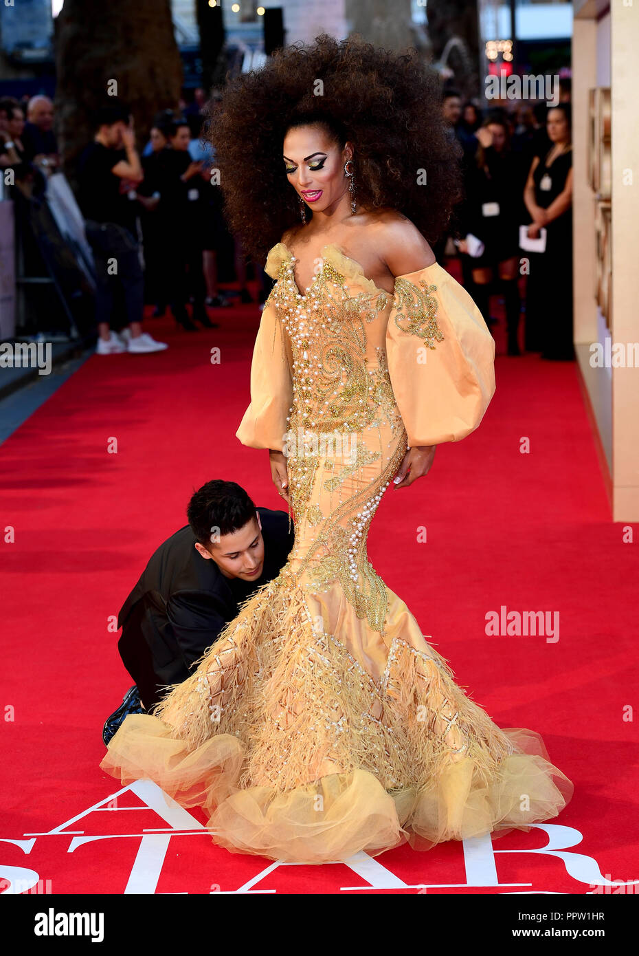 Shangela has some assistance with her dress whilst attending the UK Premiere of A Star is Born held at the Vue West End, Leicester Square, London. Stock Photo