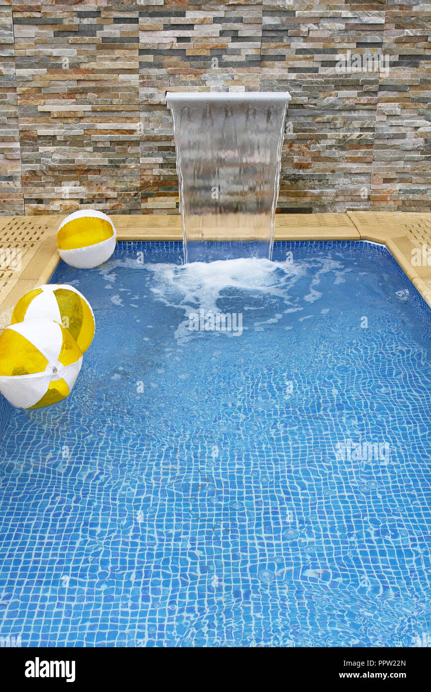 Small modern swimming pool with artificial waterfall Stock Photo