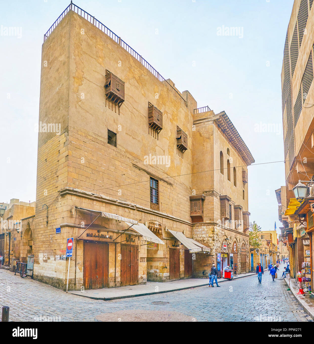CAIRO, EGYPT - DECEMBER 23, 2017: The side wall of medieval Beshtak Palace with latticework balconies and shops on the ground floor on Al-Muizz Street Stock Photo