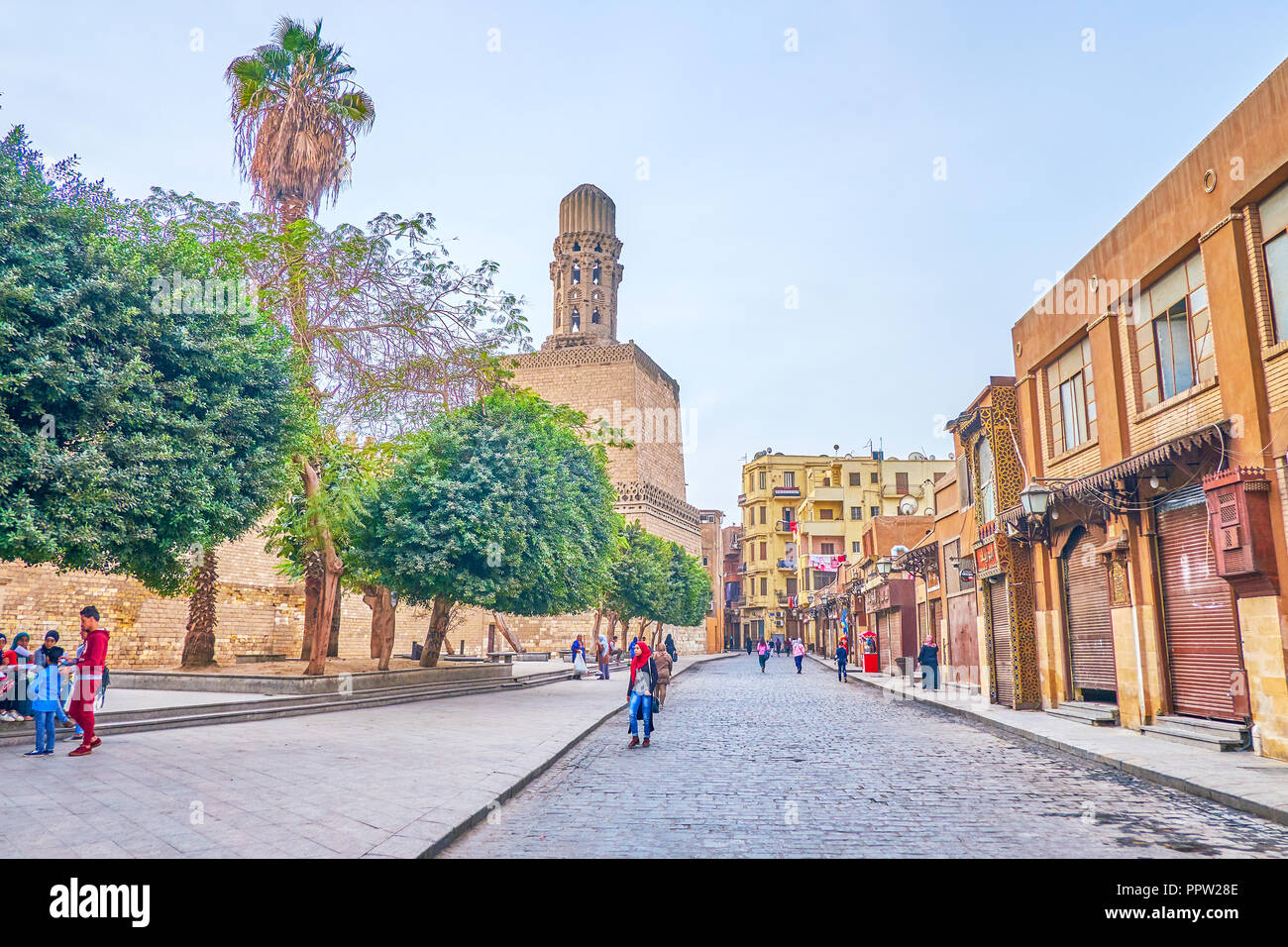 CAIRO, EGYPT - DECEMBER 23, 2017: The early morning in Al-Muizz Street with closed shops, cafes and walking teenagers, on December 23 in Cairo Stock Photo