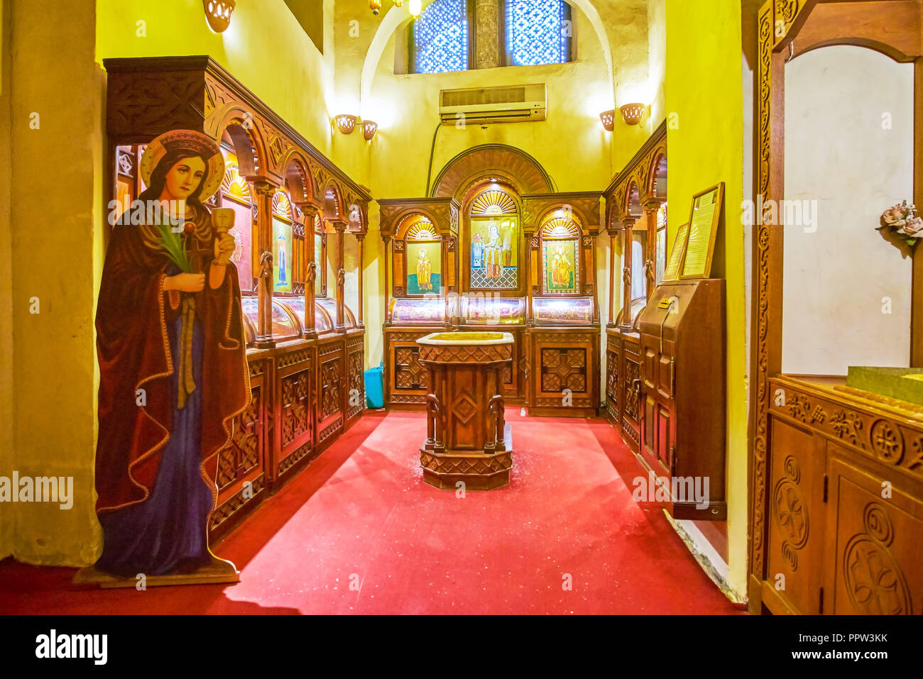 CAIRO, EGYPT - DECEMBER 23, 2017: The small chapel in Abu Serga Church decorated with medieval icons in wooden kiots and the Holy Water stoup in the m Stock Photo