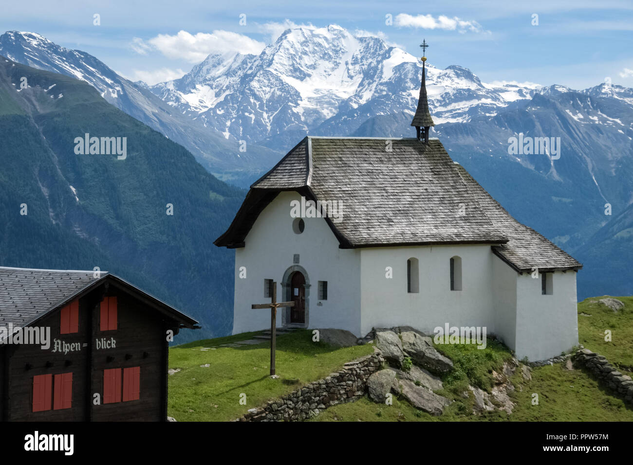 Near the village of Bettmeralp in the canton of Valais (Switzerland) a small white church is standing in the green fields Stock Photo