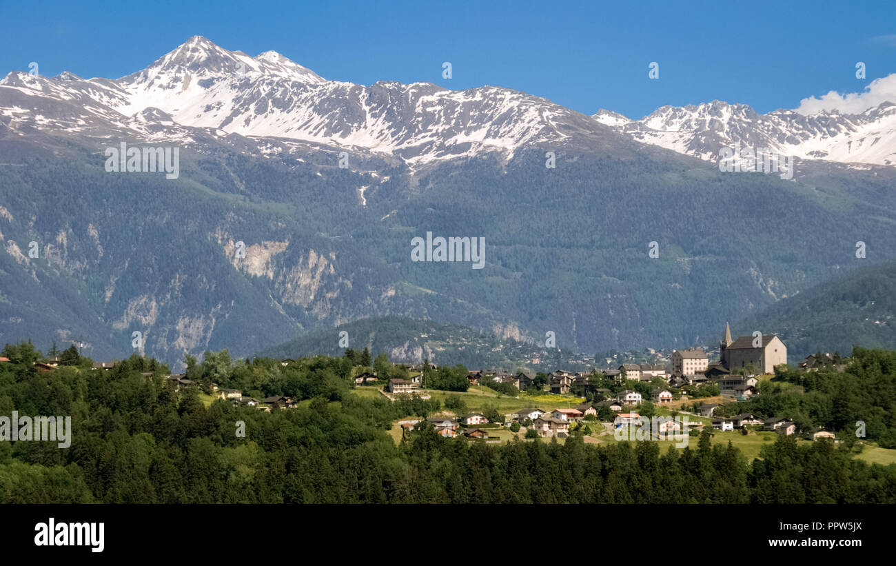 Looking towards the village of Lens on a sunny June day, located in the district of Sierre in the canton of Valais in Switzerland Stock Photo