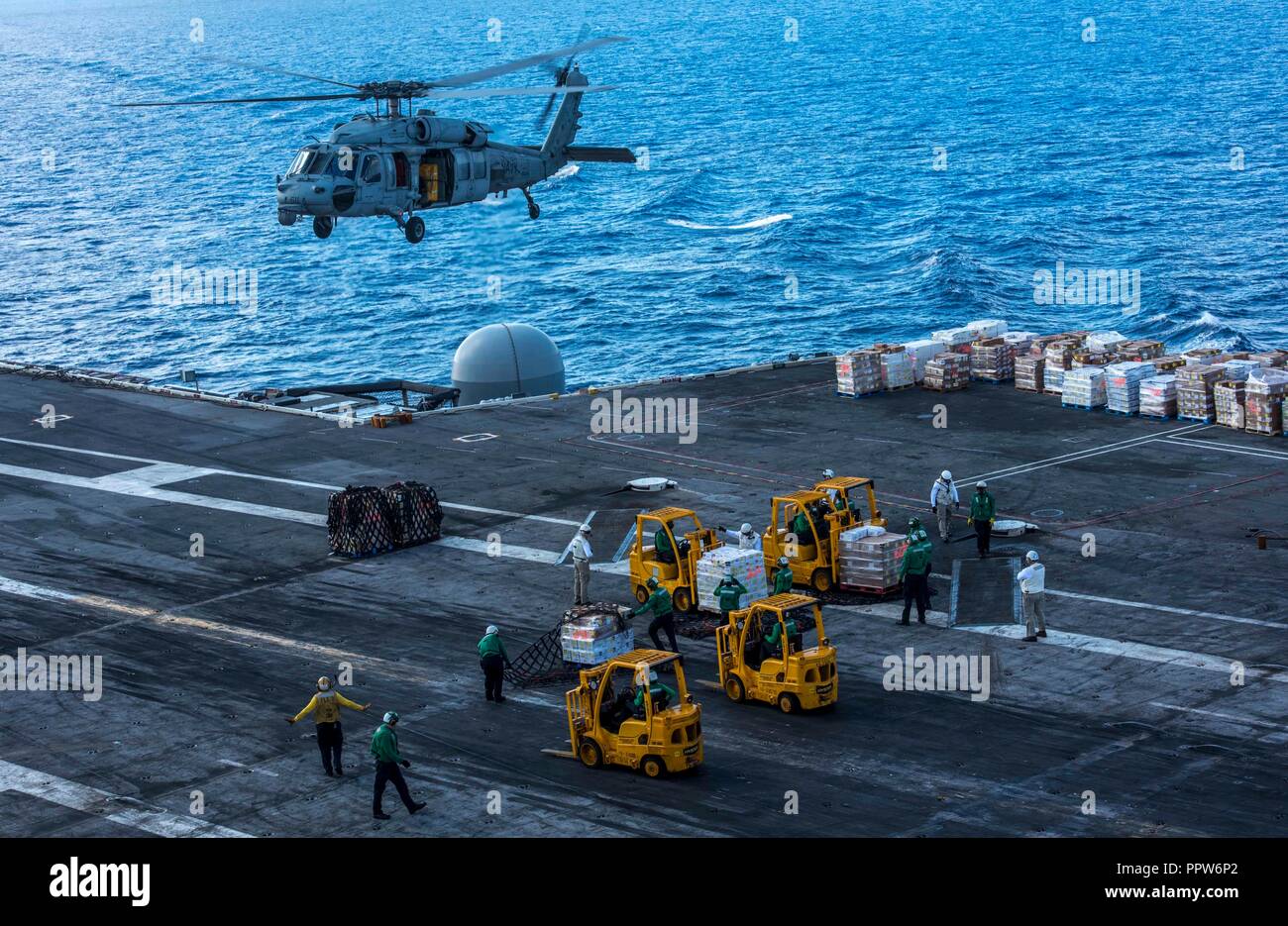 180922-N-ET513-0093 ATLANTIC OCEAN (Sept. 22, 2018) An MH-60S Sea Hawk, attached to Helicopter Sea Combat Squadron (HSC) 9, delivers a pallet of supplies during a vertical replenishment aboard the aircraft carrier USS George H.W. Bush (CVN 77). GHWB is underway in the Atlantic Ocean conducting routine training exercises to maintain carrier readiness. (U.S. Navy photo by Mass Communication Specialist 3rd Class Kallysta Castillo) Stock Photo