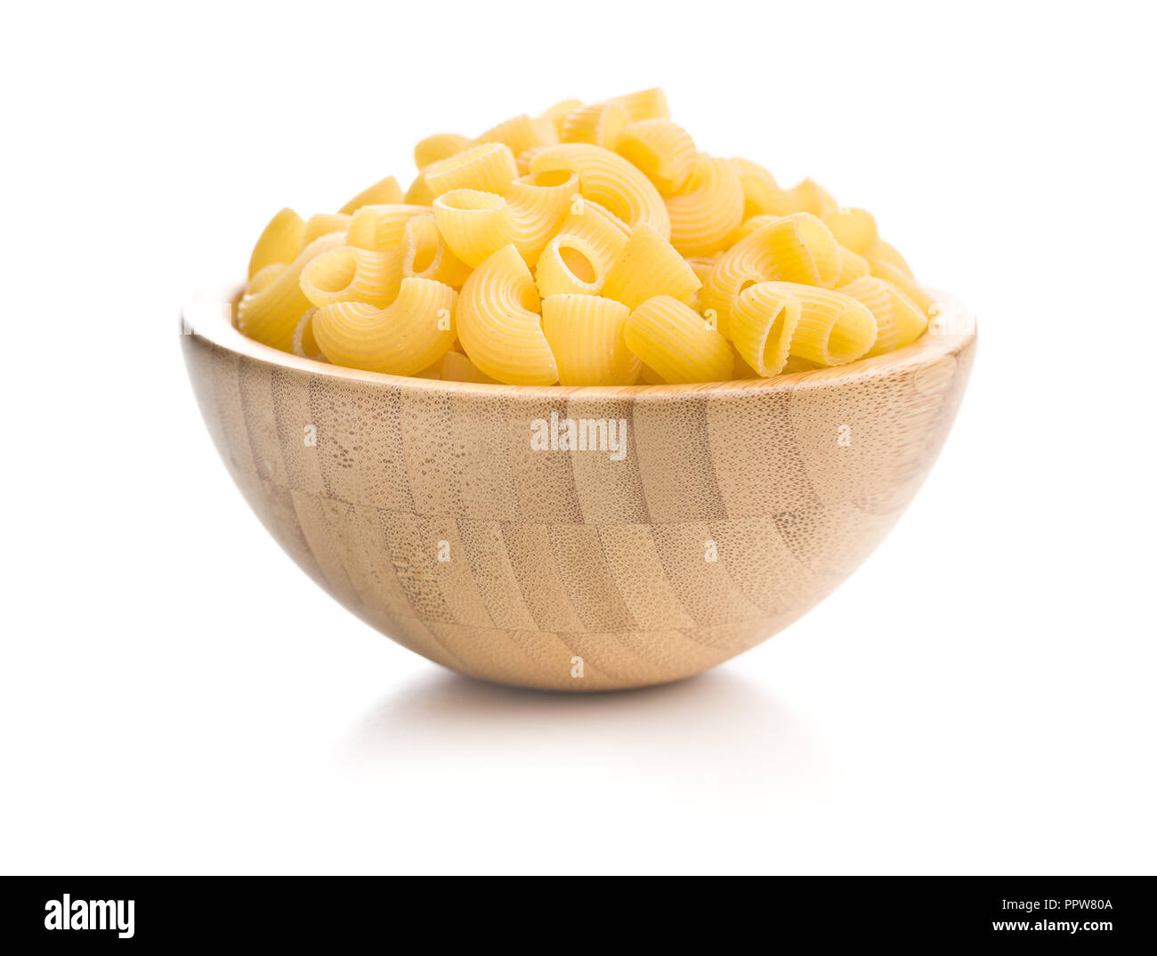 Uncooked elbow macaroni in bowl isolated on white background Stock