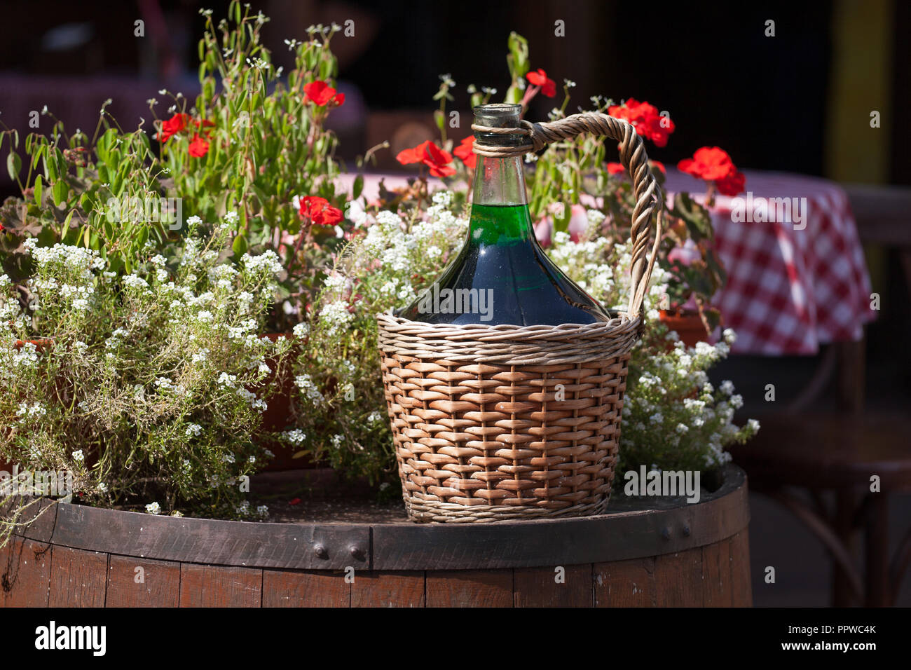 Large Vintage Wine Bottles in wicker basket on a barrel Stock Photo Alamy