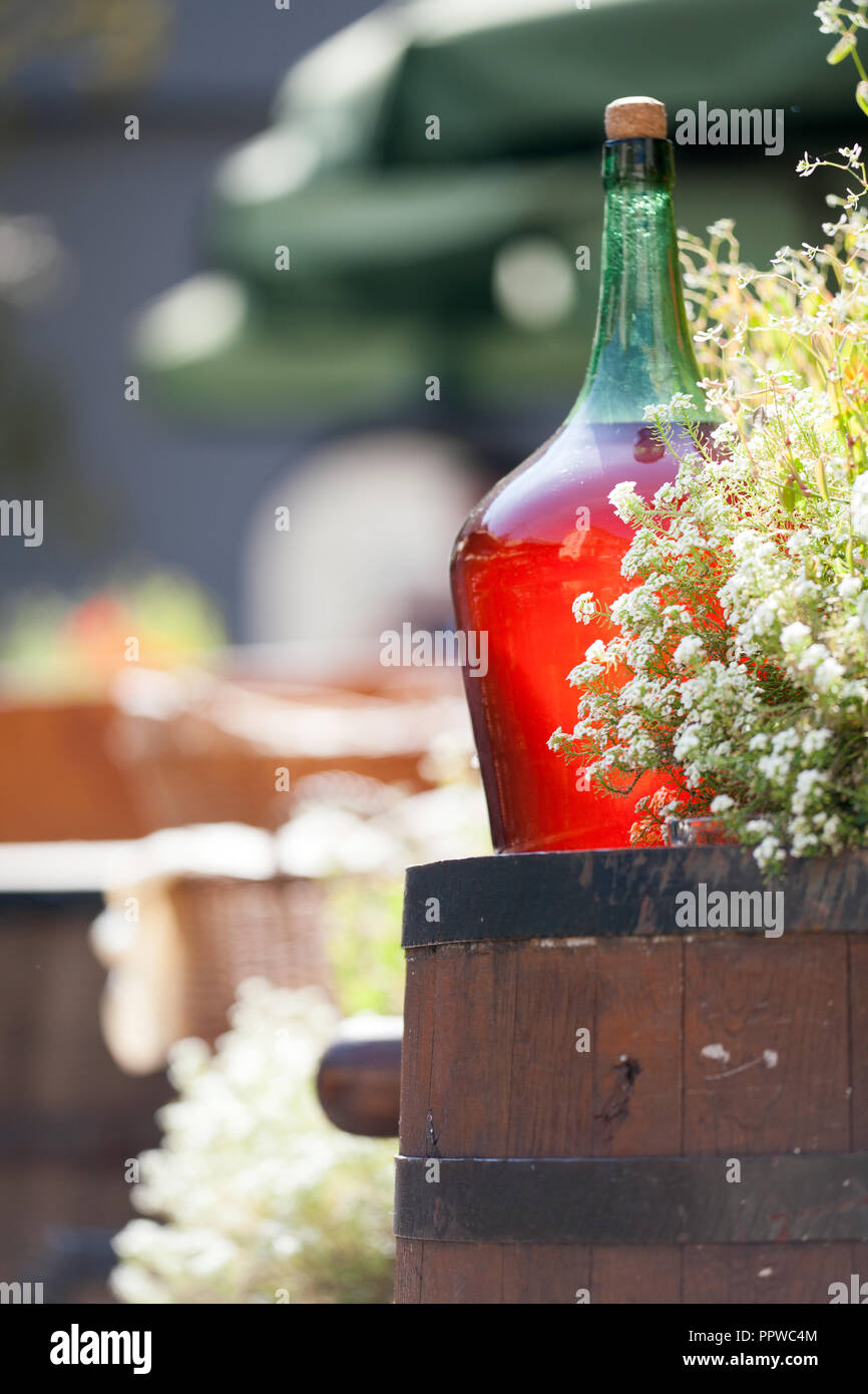 Large Vintage Wine Bottles of red wine standing on a barrel. Old sealed