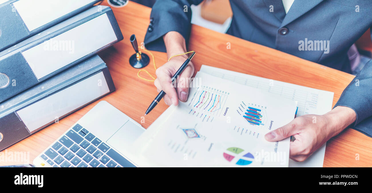 Businessmen are analyzed data from report using smartphone and laptop computer. Stock Photo