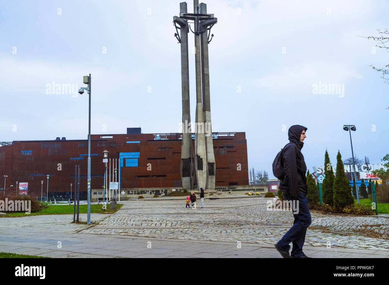 Gdansk, Pomerania, Poland : A man walks through Solidarity Square. In background, the European Solidarity Centre (opened 2014) next to the entrance to Stock Photo