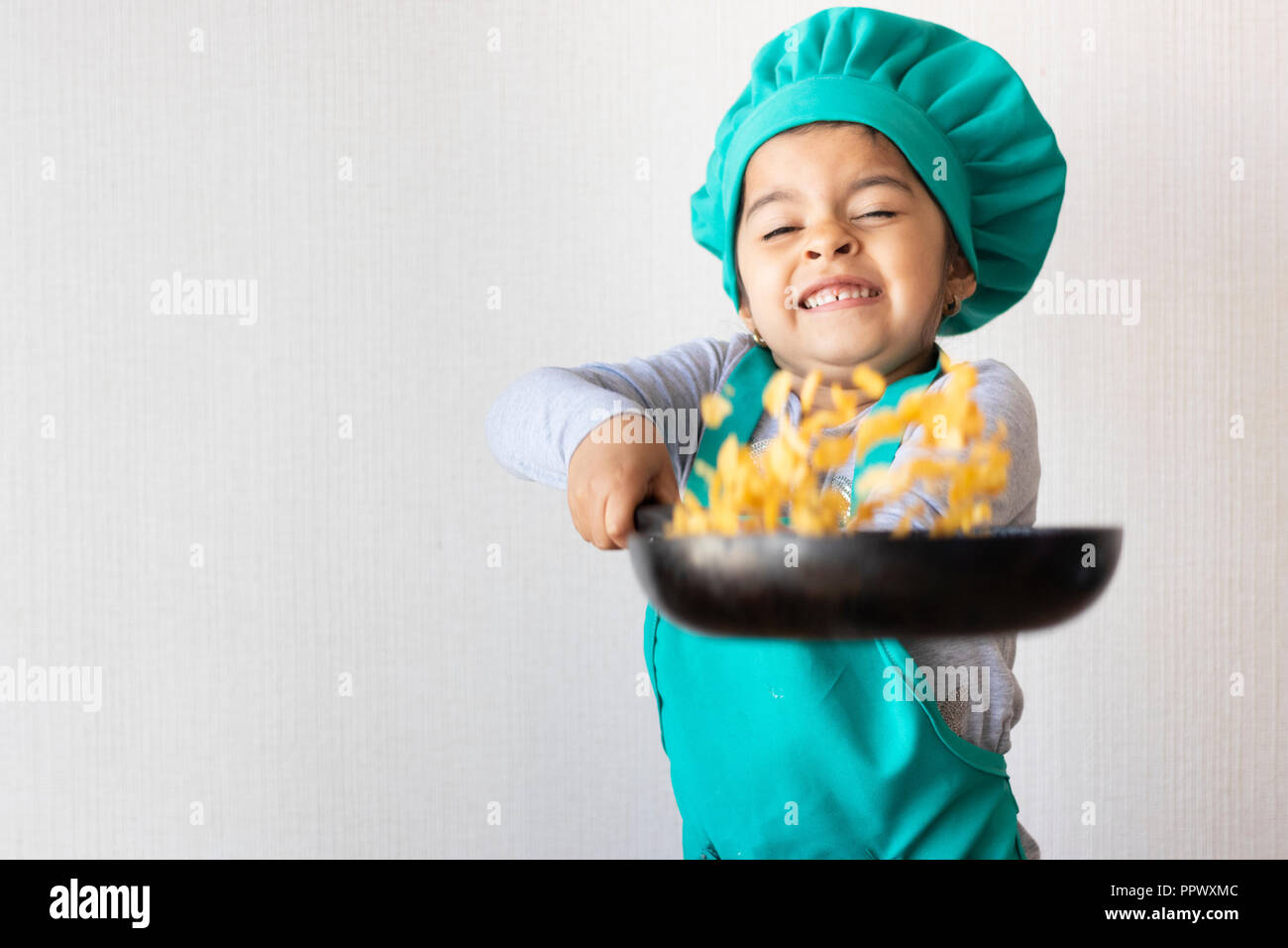 Cute little girl cooking with her frying pan in the kitchen Stock Photo ...