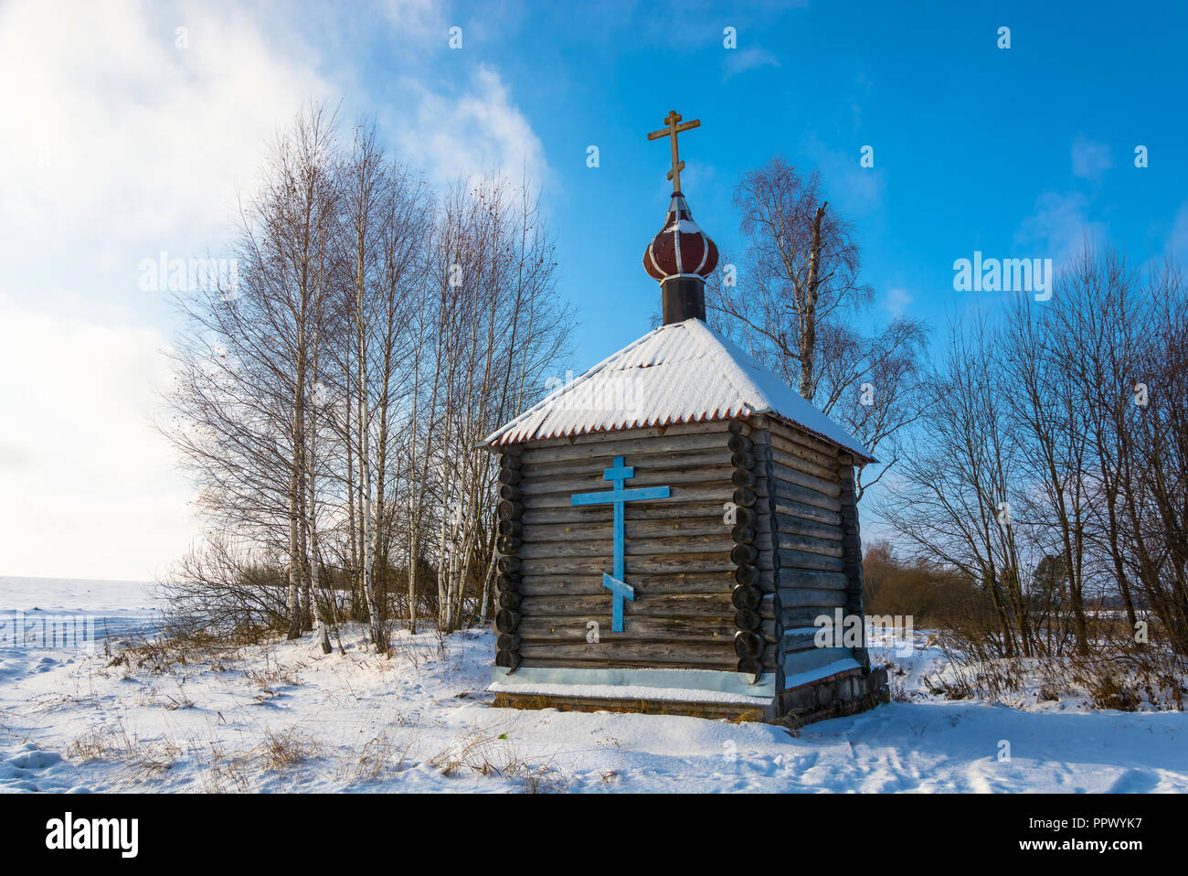 Wooden chapel on the sacred source of the Tikhvin icon of the Mother of God near the village of Podolino in winter Sunny day. Palekh district, Ivanovo Stock Photo