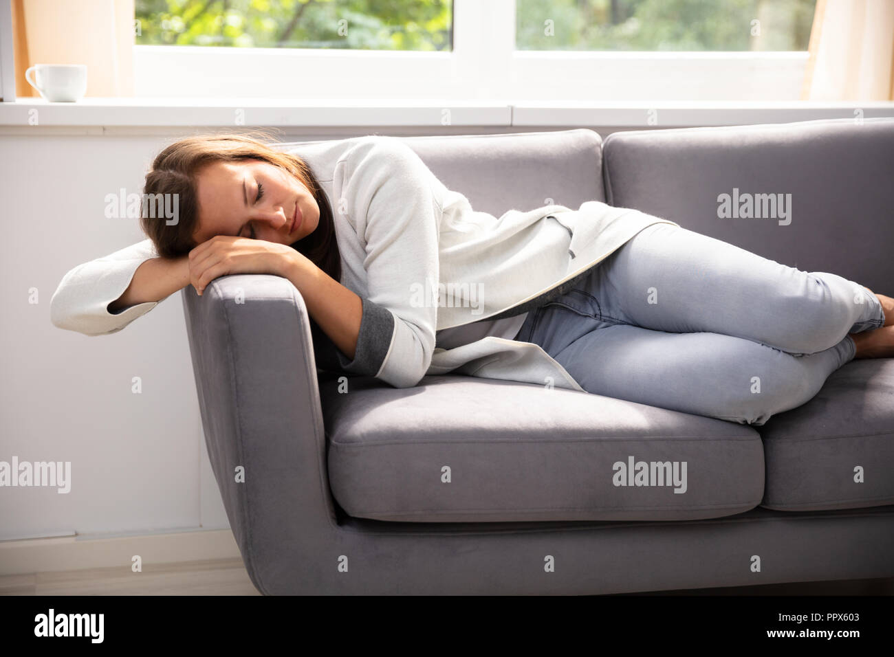 Beautiful Young Woman Sleeping On Sofa At Home Stock Photo