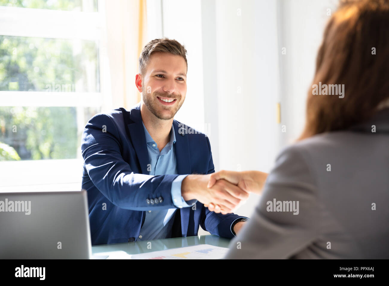 Smiling Young Businessman Shaking Hands With His Partner Stock Photo