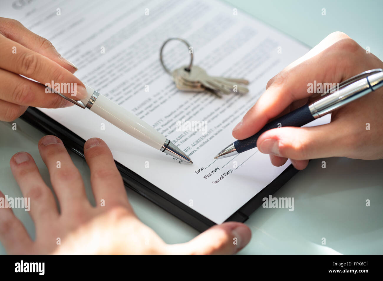 Close-up O A Real Estate Agent Helping Client In Filling Contract Form ...