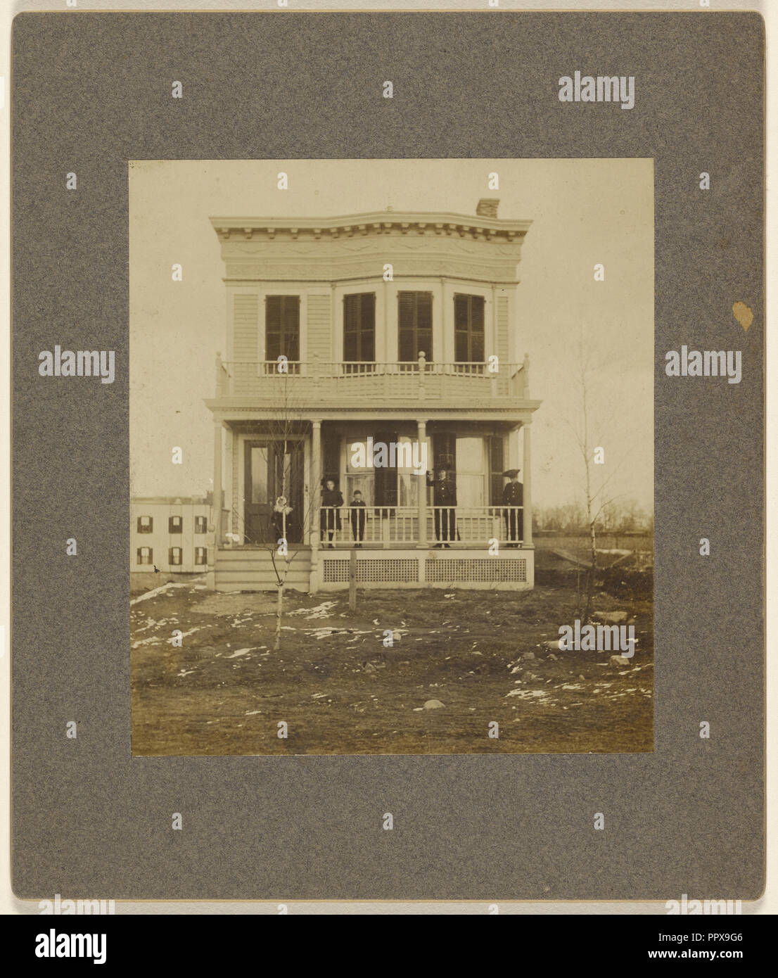 View of a Victorian-style house with five people on the front porch; 1890s; Gelatin silver print Stock Photo