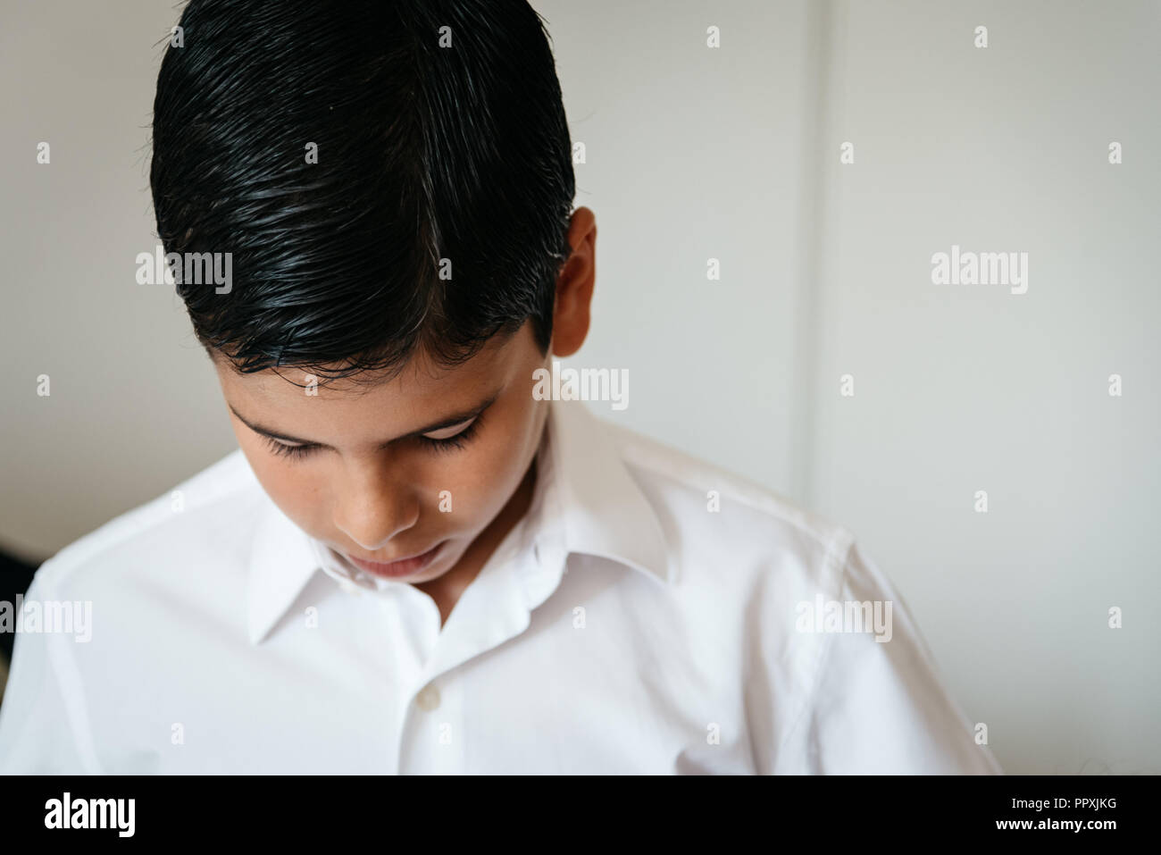 Young boy getting ready for celebration. He is looking down Stock Photo