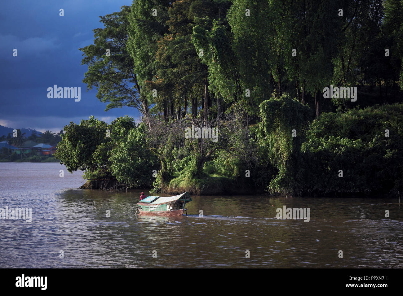 Sampan wooden boat ferries people across the Sarawak River in Kuching, Borneo Stock Photo