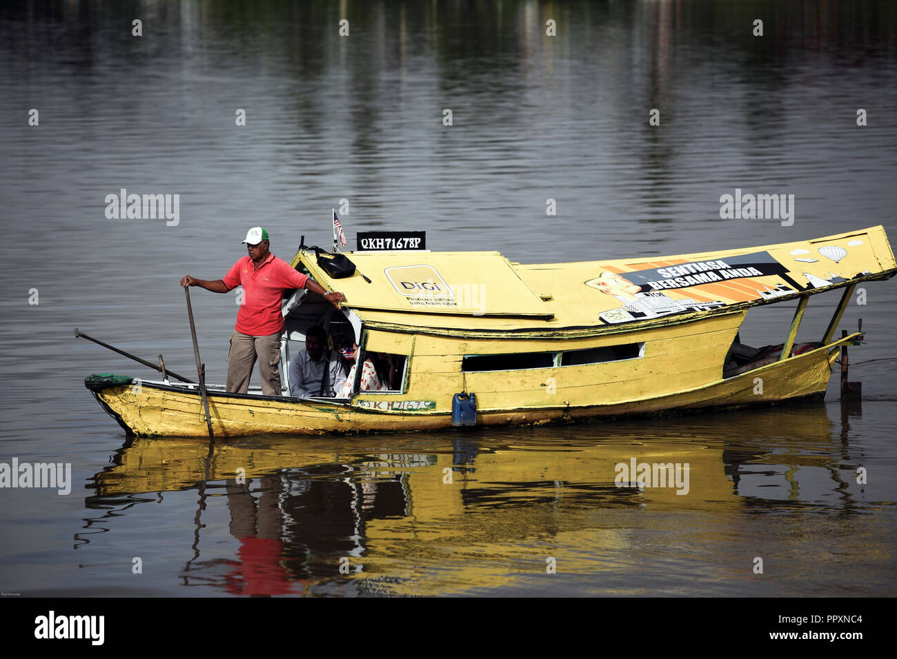Sampan wooden boat ferries people across the Sarawak River in Kuching, Borneo Stock Photo