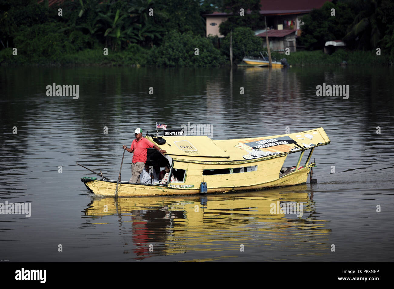 Sampan wooden boat ferries people across the Sarawak River in Kuching, Borneo Stock Photo