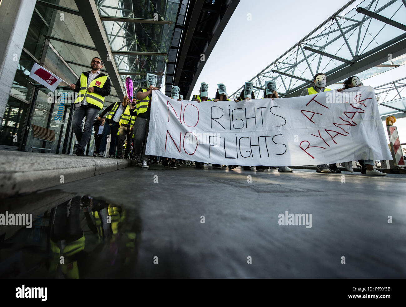 28 September 2018, Hessen, Frankfurt Main: Flight attendants of low-cost airline Ryanair demonstrate with a strike banner and masks at Terminal 2 of Frankfurt Airport. Trade unions in several European countries have called for strikes at the low-cost airline. In Germany, the pilots of the Cockpit Association (VC) and the flight attendants organized by Verdi participate. Photo: Andreas Arnold/dpa Stock Photo