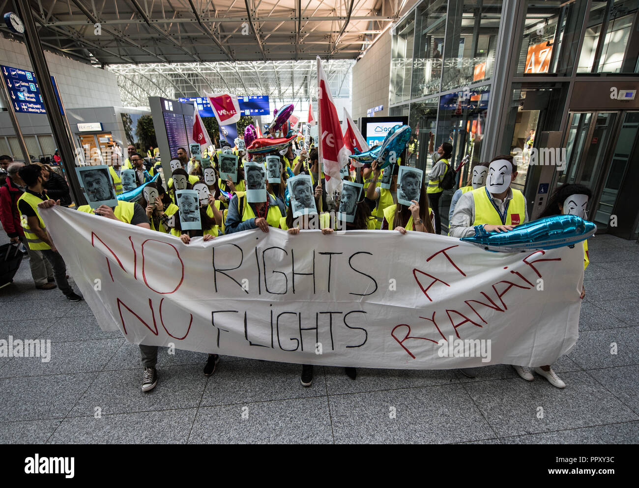 28 September 2018, Hessen, Frankfurt Main: Flight attendants of low-cost airline Ryanair demonstrate with a strike banner and masks in Terminal 2 of Frankfurt Airport. Trade unions in several European countries have called for strikes at the low-cost airline. In Germany, the pilots of the Cockpit Association (VC) and the flight attendants organized by Verdi participate. Photo: Andreas Arnold/dpa Stock Photo