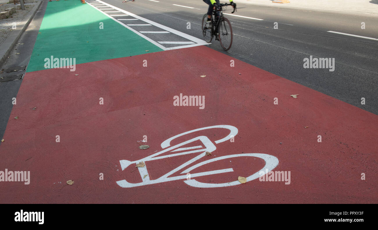 28 September 2018, Berlin: A cyclist passes the newly designed cycle path on Holzmarktstraße. It is the first cycle path to be designed in colour. At potential danger points such as entrances and exits or junctions, the cycle path is marked in the colour 'red', otherwise in the colour 'green'. Other cycle paths in the city are now being gradually converted to give cyclists a greater sense of security. Photo: Paul Zinken/dpa Stock Photo