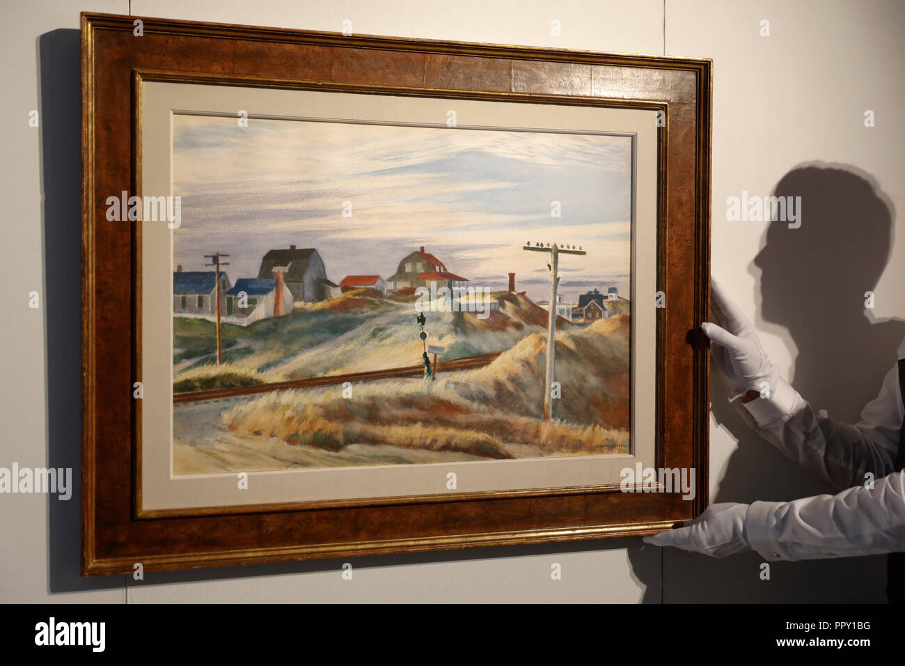 London, UK. 28th Sep 2018. Christie's employee posew with artist Edward Hopper's work 'Cottages at North Truro, MA' at Christie's auction house in London, Friday September 28, 2018.  It is expected to achieve up to $3million when it comes to sale in New York in November. Photograph : © Luke MacGregor Credit: Luke MacGregor/Alamy Live News Stock Photo